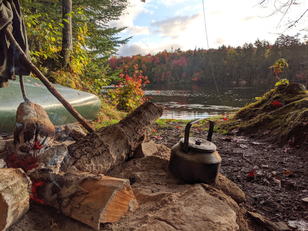 a kettle by a canoe campfire